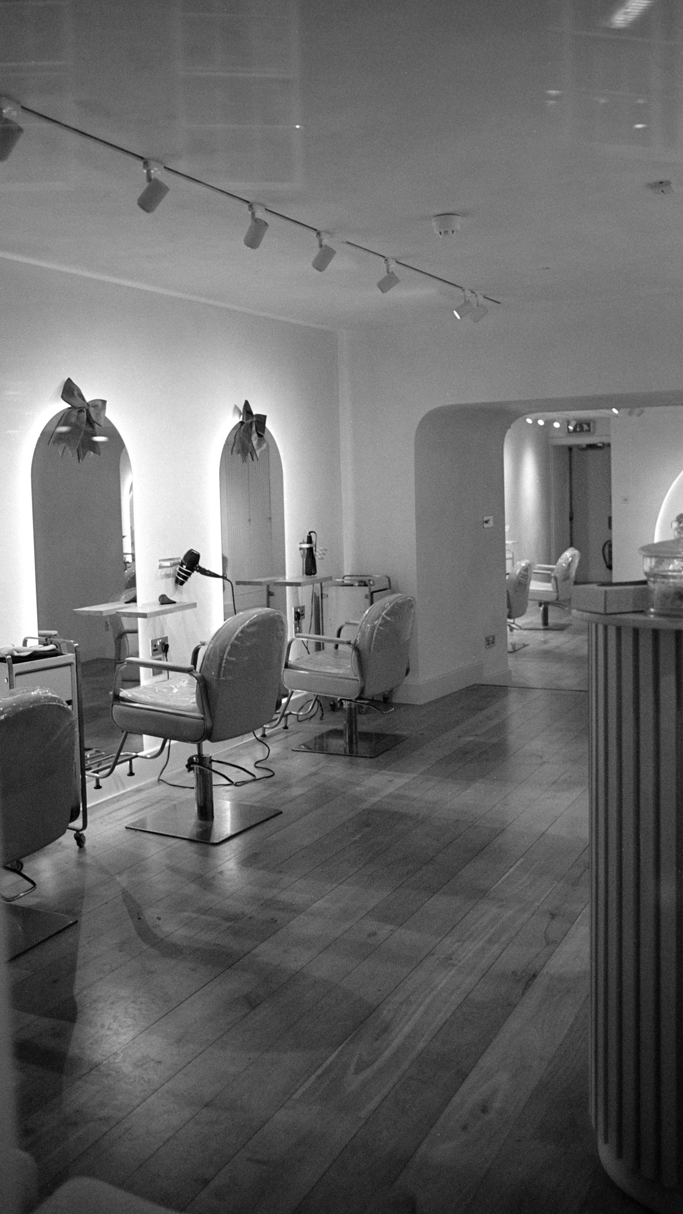 Light-filled salon with arched mirrors and styling chairs — representative stock photograph